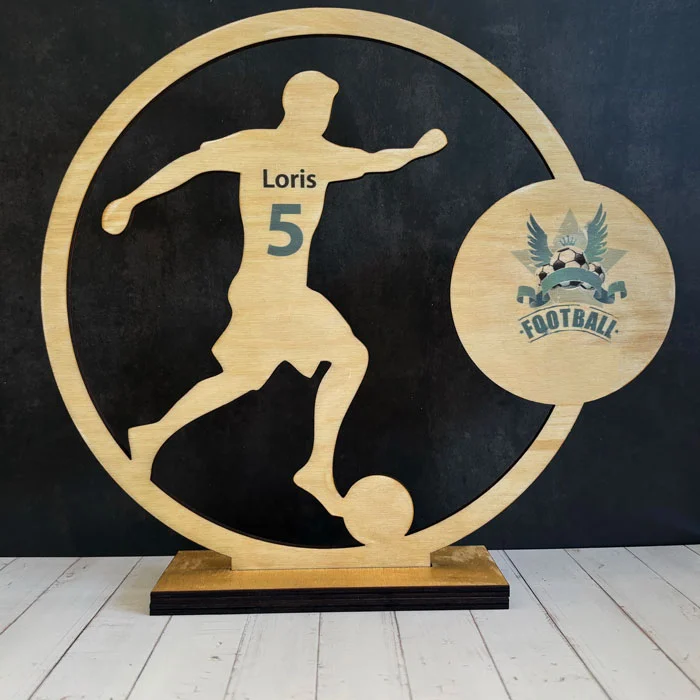 Trophée de football en bois découpé à la forme représentant un joueur, avec gravure personnalisée du nom et numéro.