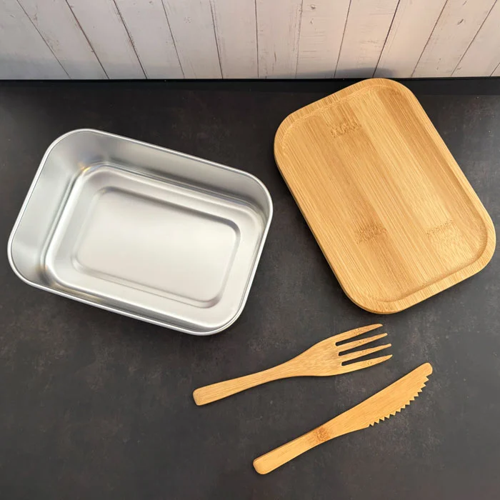Boîte repas écologique en acier inoxydable avec couvercle en bois de bambou et couverts assortis.