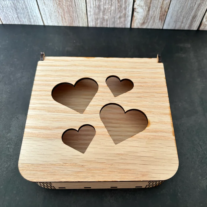 Boîte carrée en bois naturel avec couvercle ajouré découpé de quatre cœurs